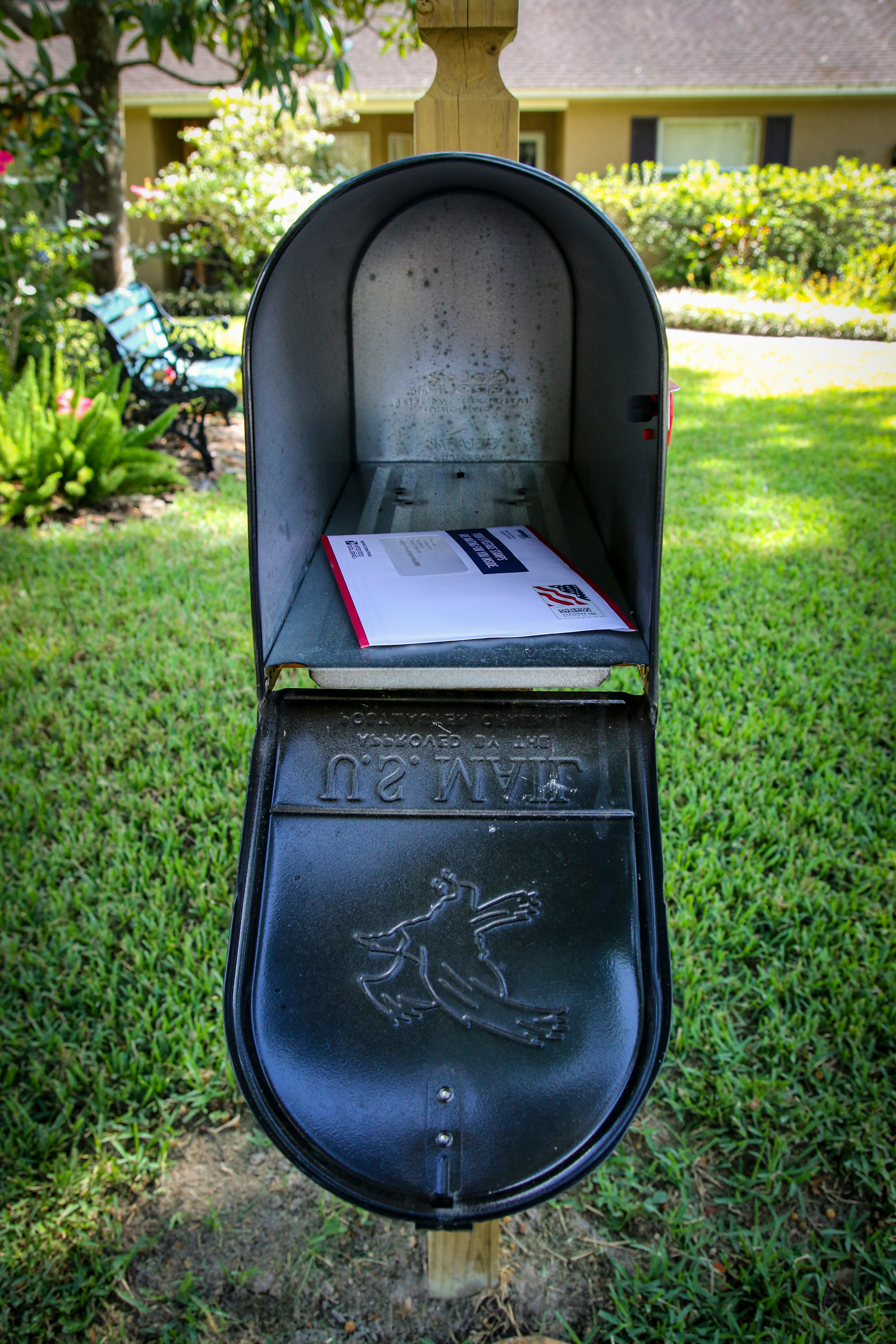 blue and white mail box on green grass field