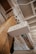 A wooden post supports a white sign with black uppercase text that reads 'PICKLETOWN FLOWER CO.' The setting appears to be indoors, likely a store or workshop with exposed beams and industrial elements like pipes and wires visible in the ceiling area.