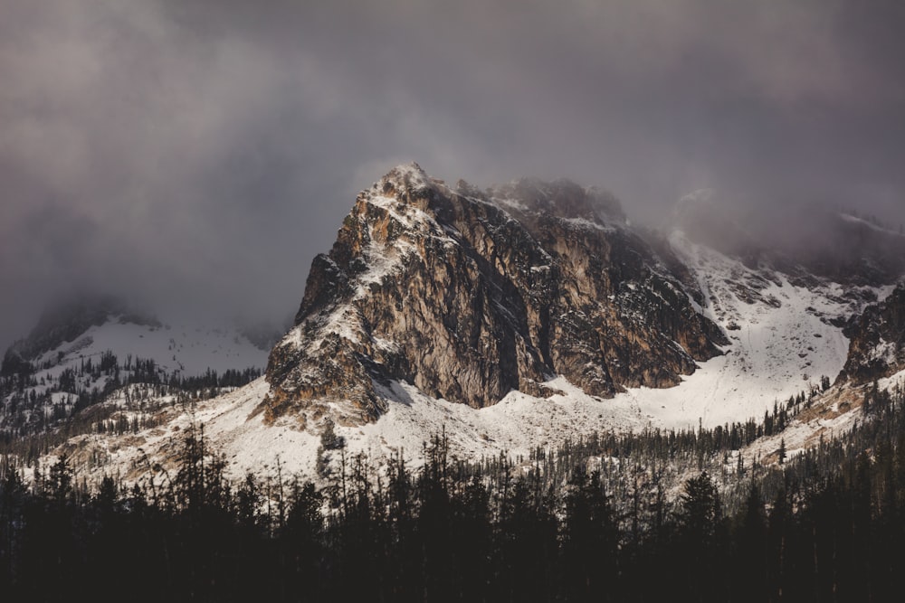 snow covered mountain under cloudy sky