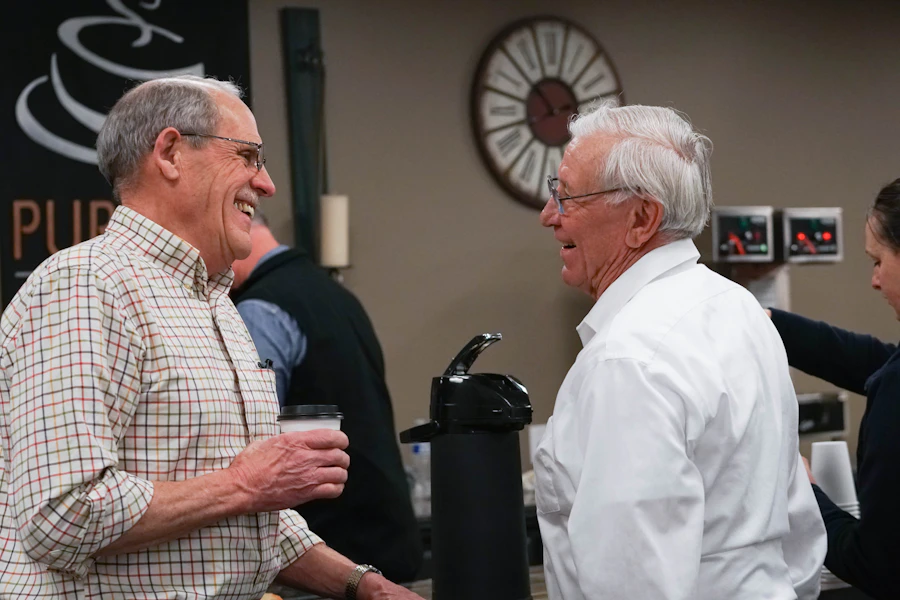 People chatting over coffee before a support group