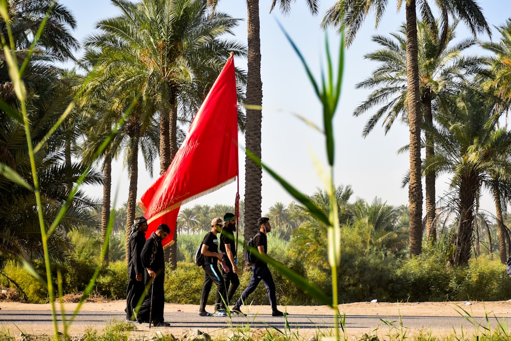 昼間、赤と白の旗を掲げて通りを歩く人々