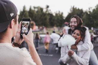 woman in white dress holding black smartphone