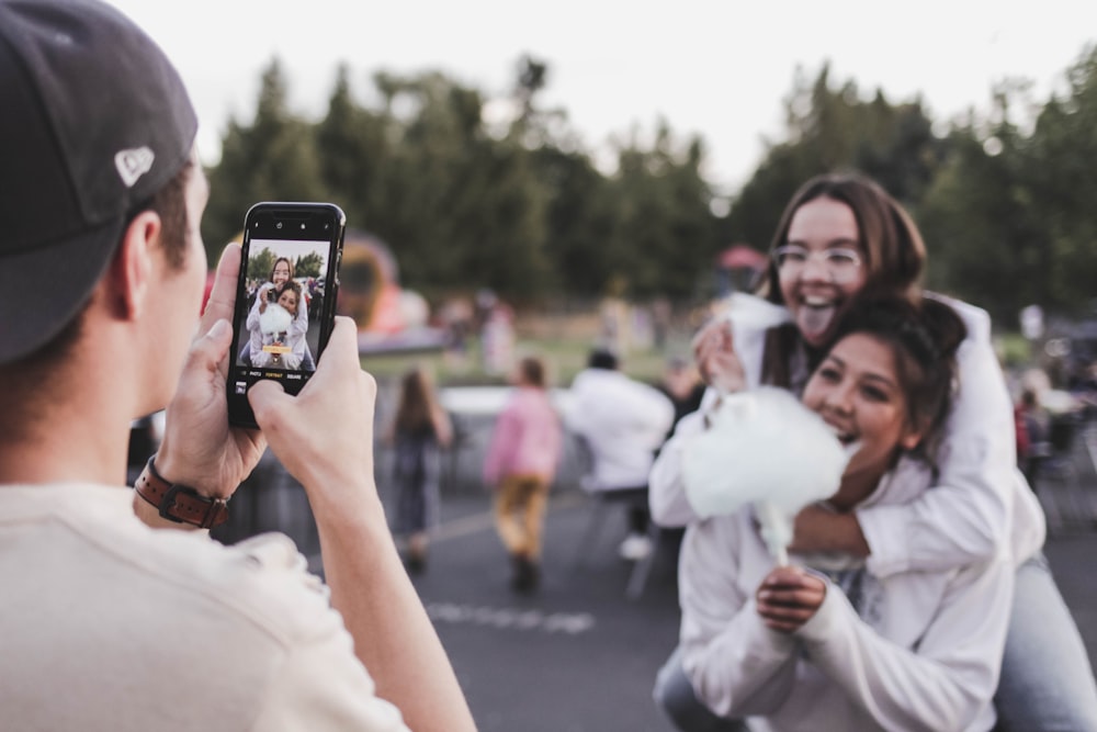 woman in white dress holding black smartphone