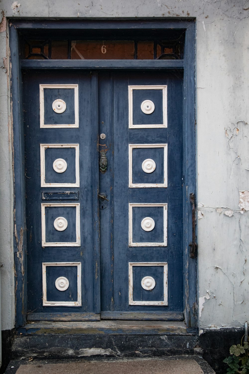 blue wooden door on white concrete wall