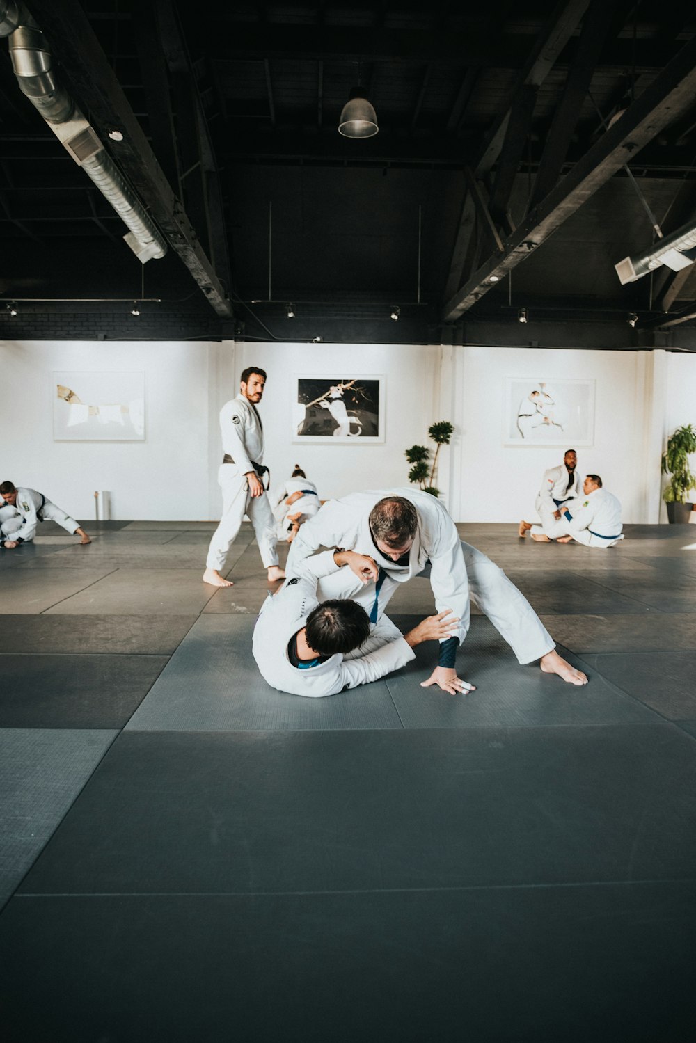 man in white long sleeve shirt and black pants sitting on black floor