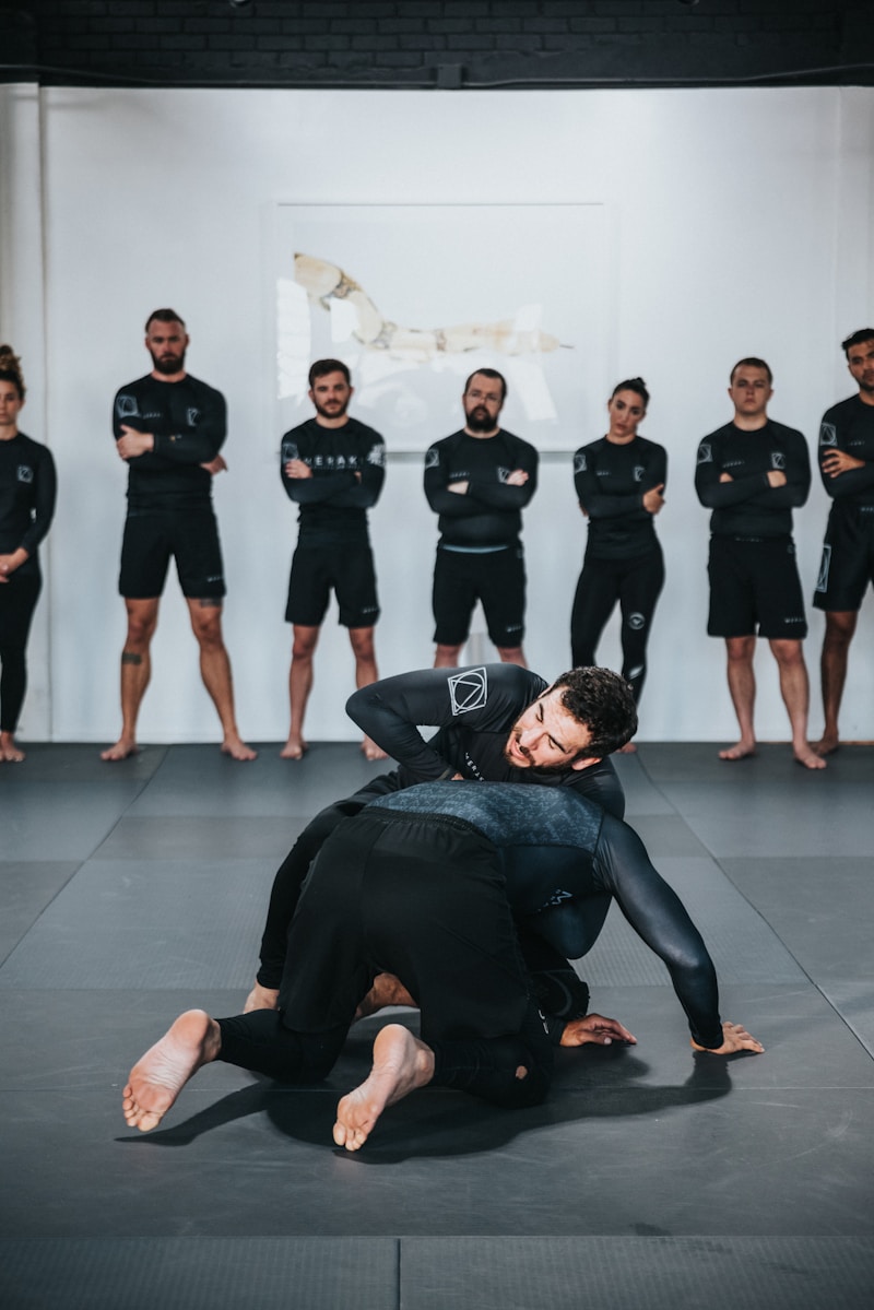 Group of BJJ athletes in no-gi gear training at a competitive grappling academy