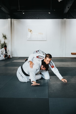 Instructor guiding a student through Muay Thai techniques in a clean, minimalist space.