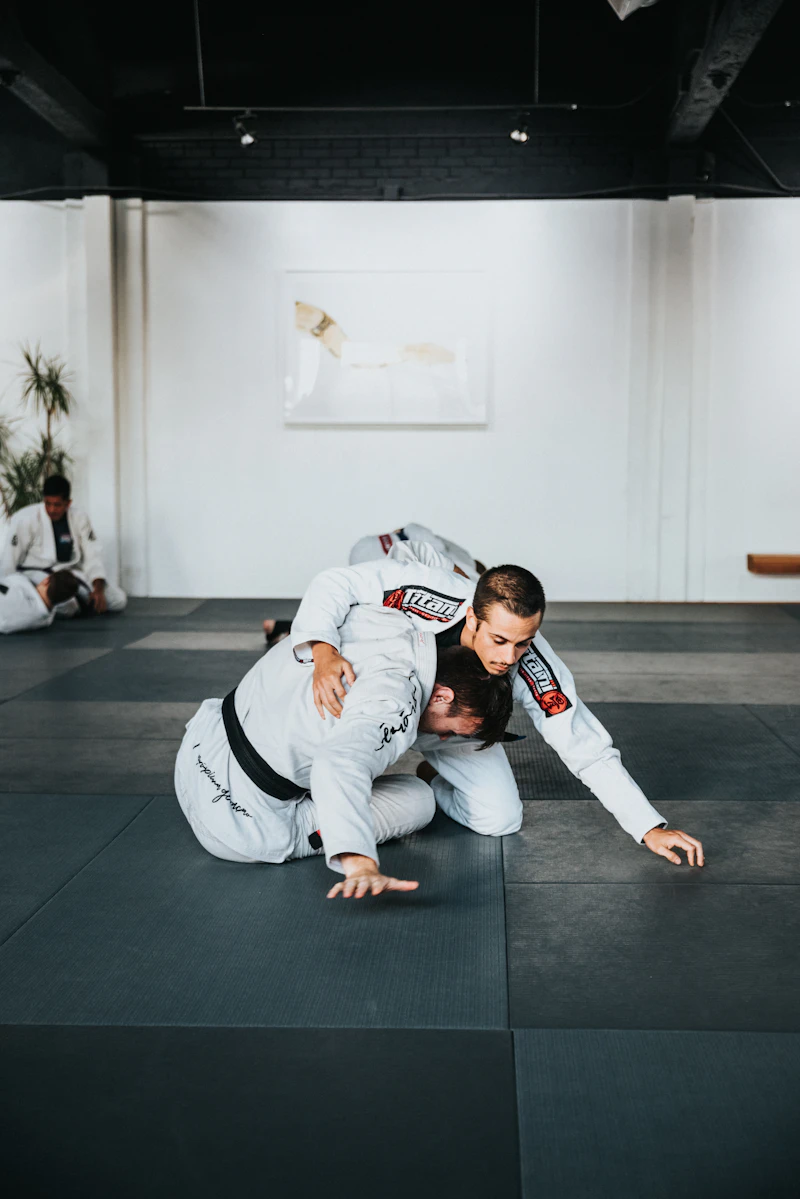 Dos practicantes de jiu-jitsu brasileño entrenando en el tatami