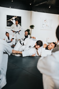 An instructor guiding a student through a defensive aikido posture in a supportive setting.