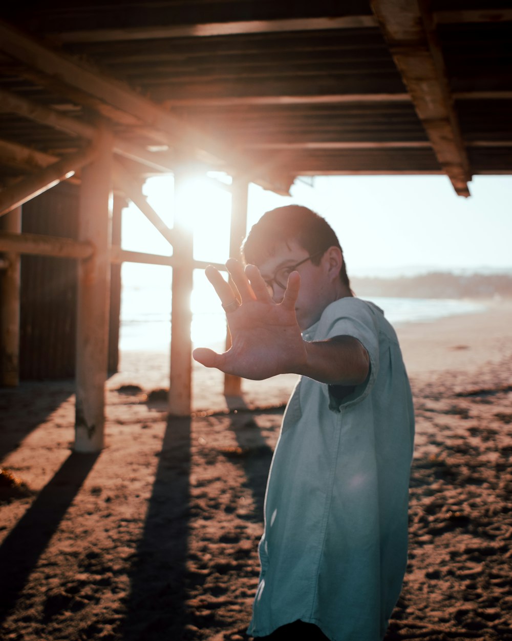 man in white dress shirt standing on brown sand during daytime