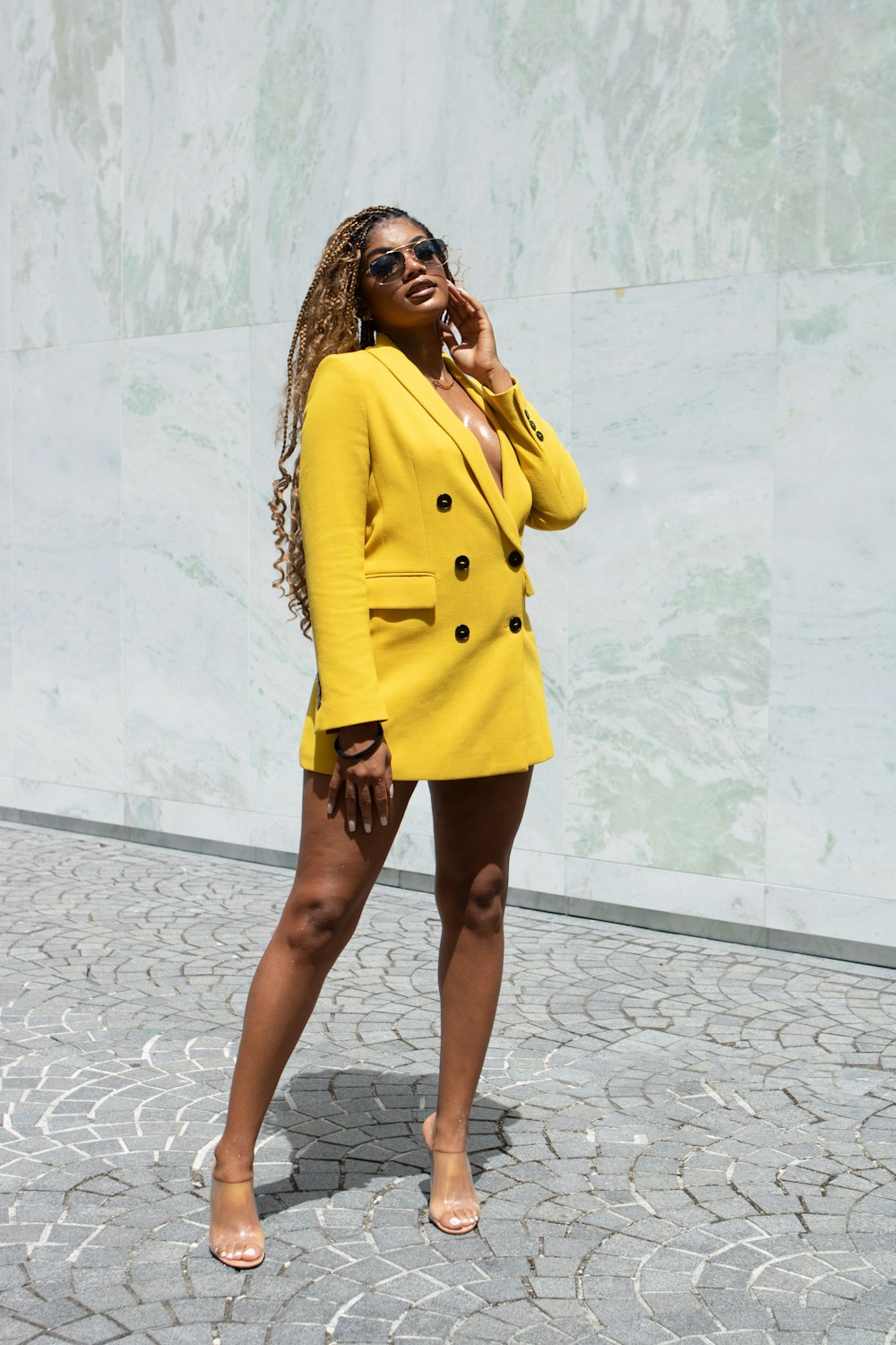 woman in yellow blazer standing near white wall