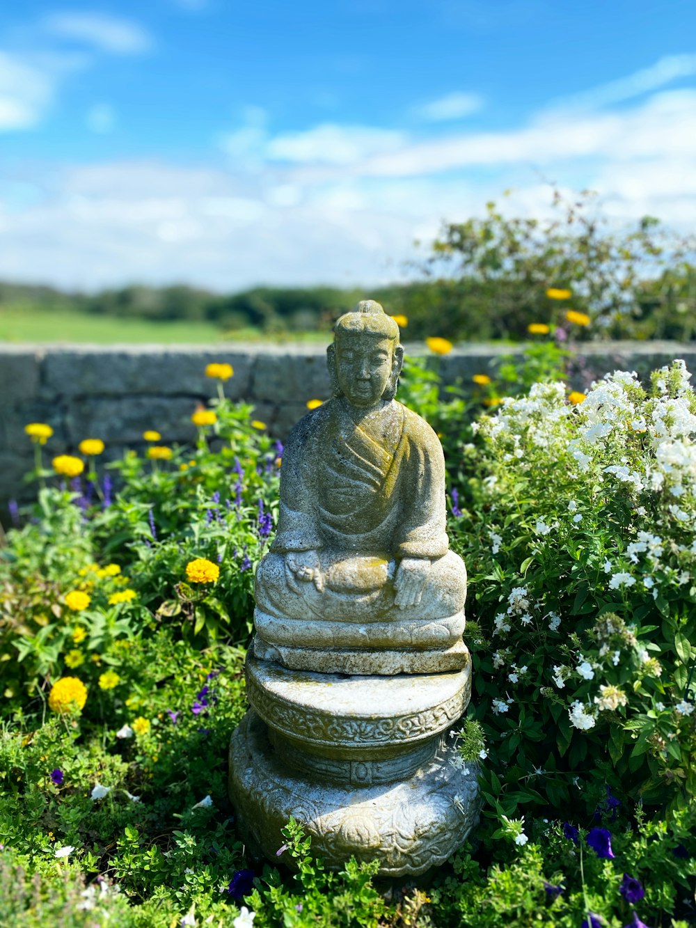 gold buddha statue on green grass field during daytime