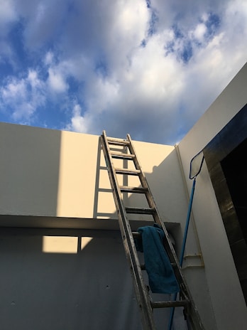 A ladder leaning against a house ready for roof inspection.