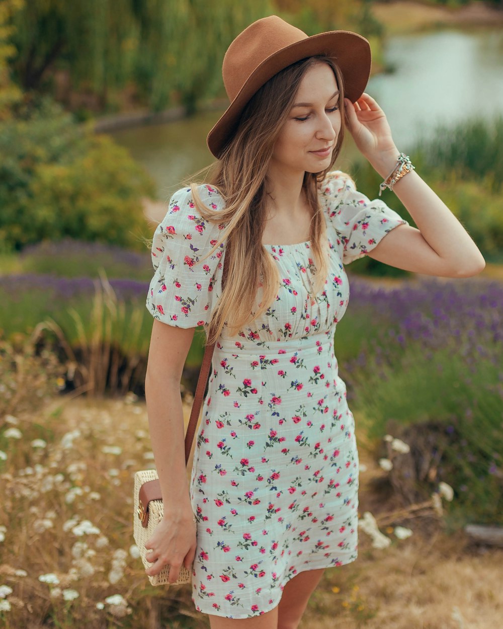 woman in white and red floral dress wearing brown hat