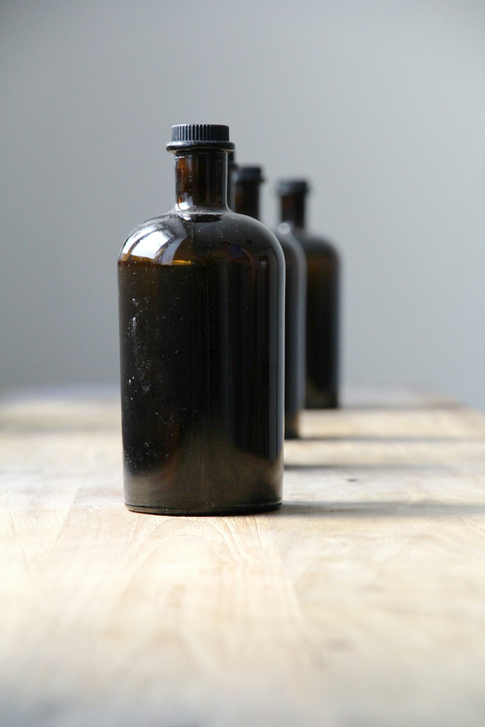 black glass bottle on white textile