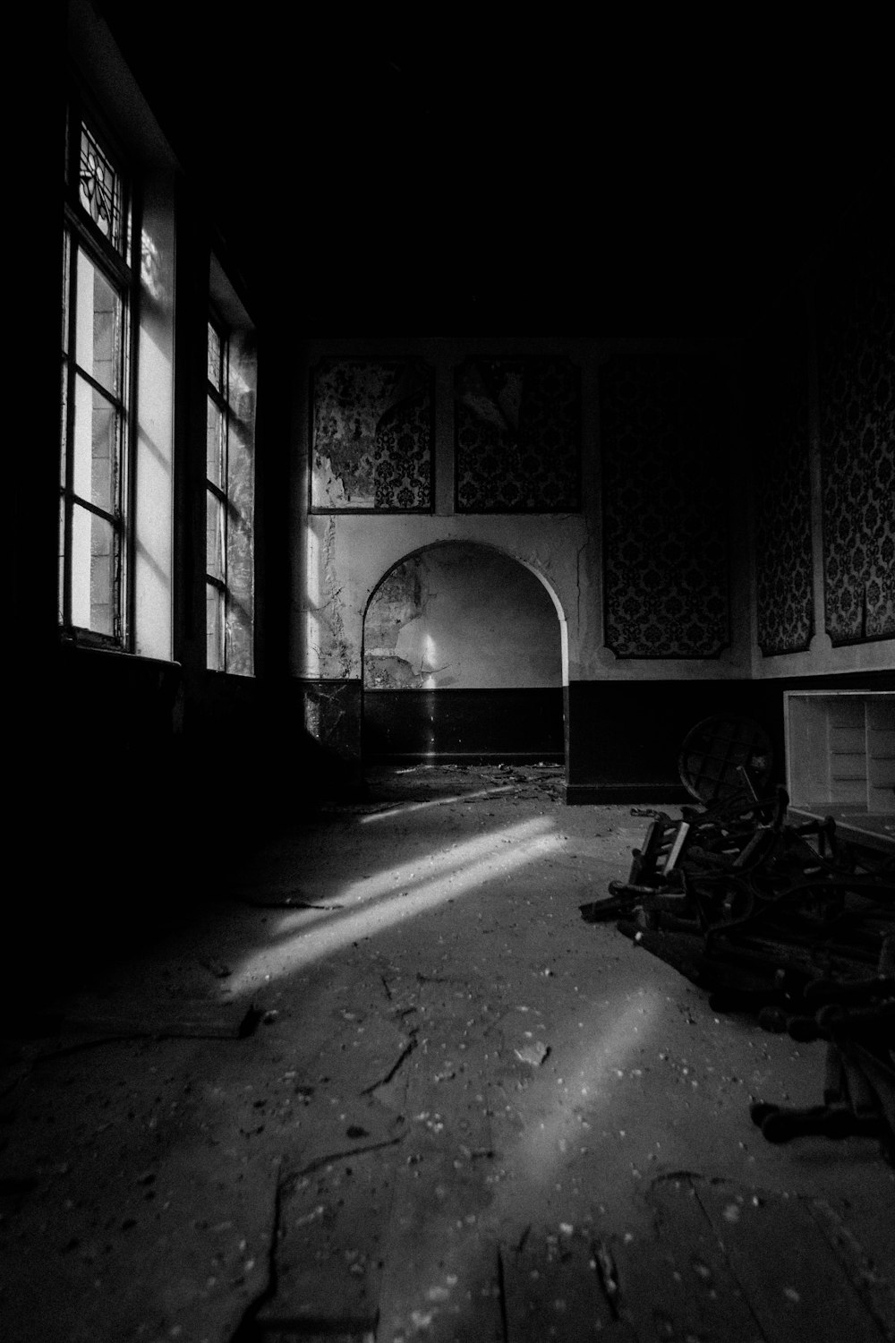 grayscale photo of tunnel with arch shaped window