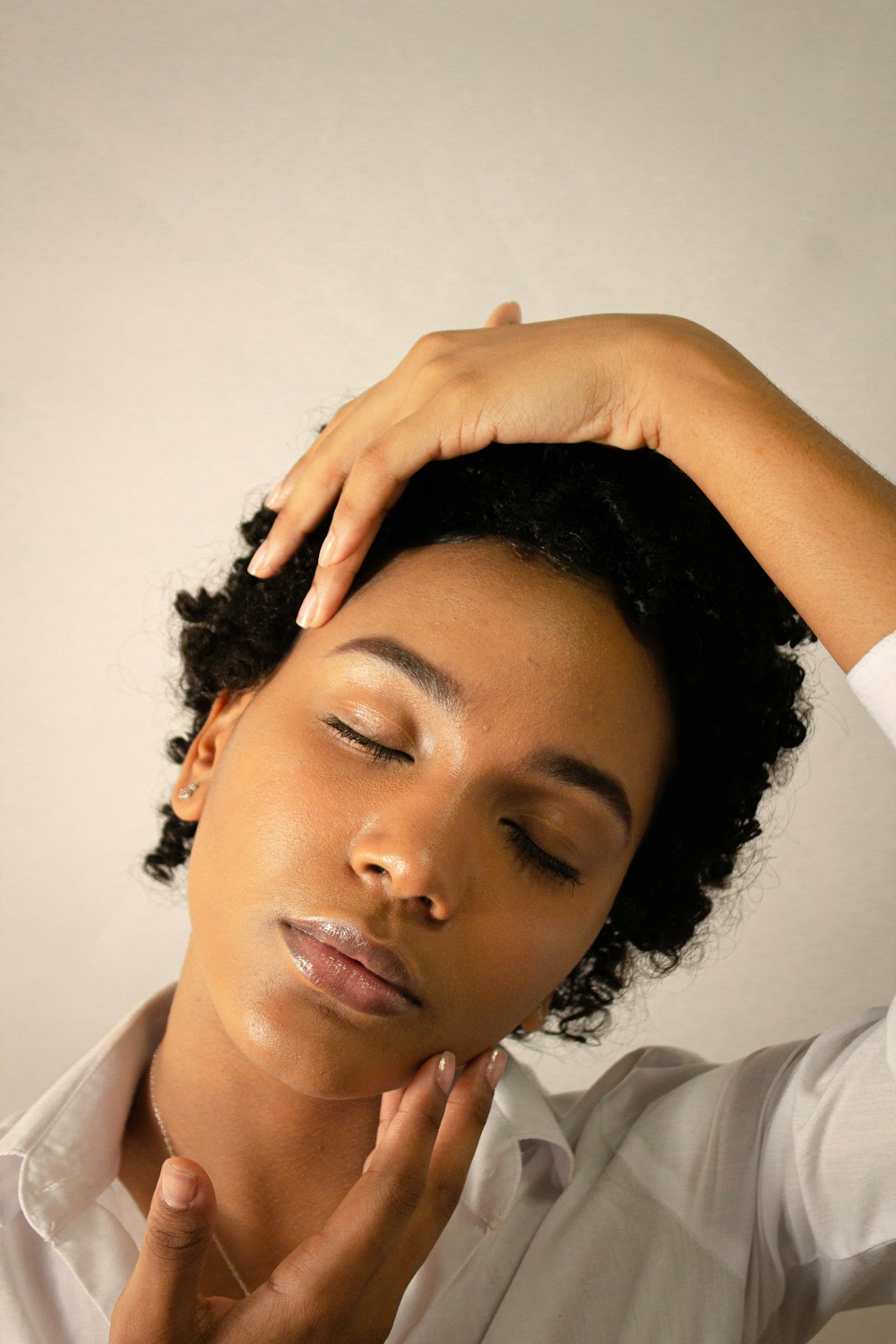 woman in white shirt holding her hair