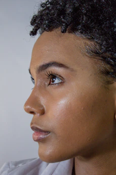Close-up of a glowing, dewy face with soft natural light highlighting clear skin.