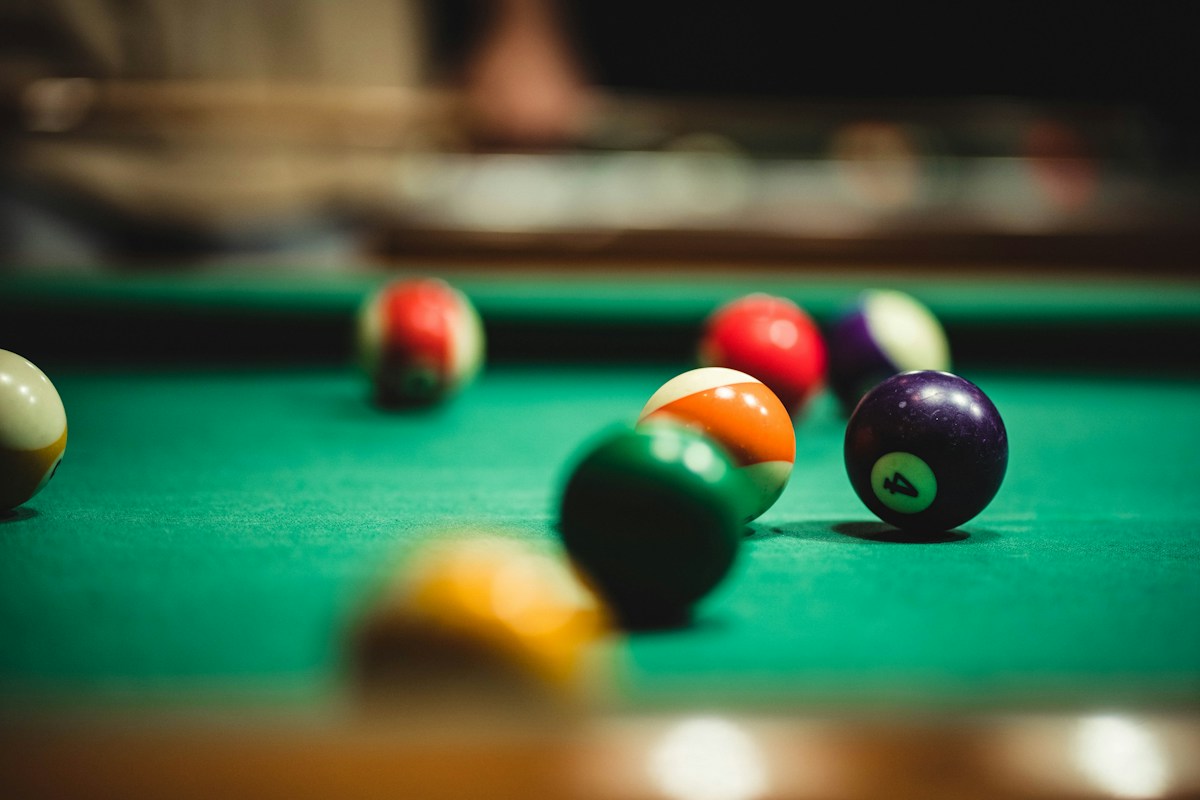 Billiard balls arranged on a pool table, illustrating how cause and effect transmits through a chain