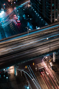 A dynamic aerial shot of illuminated highways converging at night, symbolizing rapid transit and connectivity.