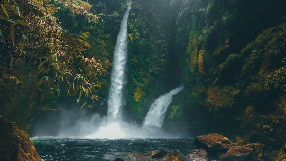 waterfalls on brown rocky mountain during daytime