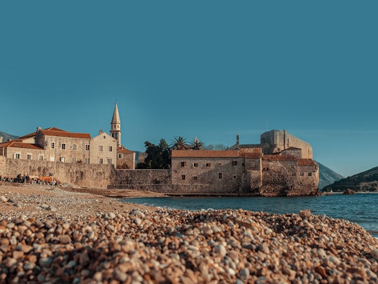 brown concrete building near body of water during daytime in Budva Old Town Montenegro