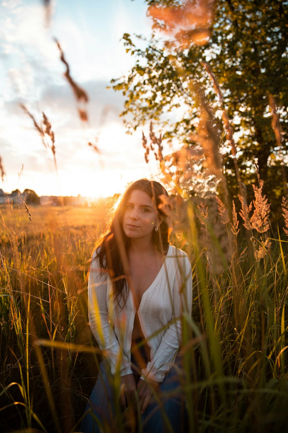 woman in white long sleeve shirt standing on green grass field during daytime