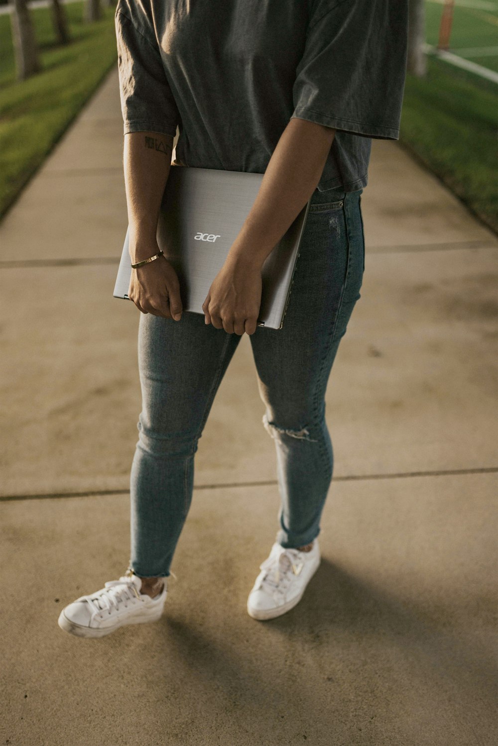 person in blue denim jeans and white sneakers