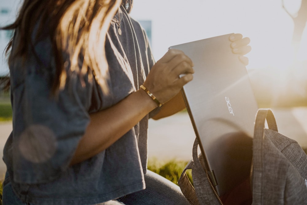 woman in blue denim jacket holding white paper