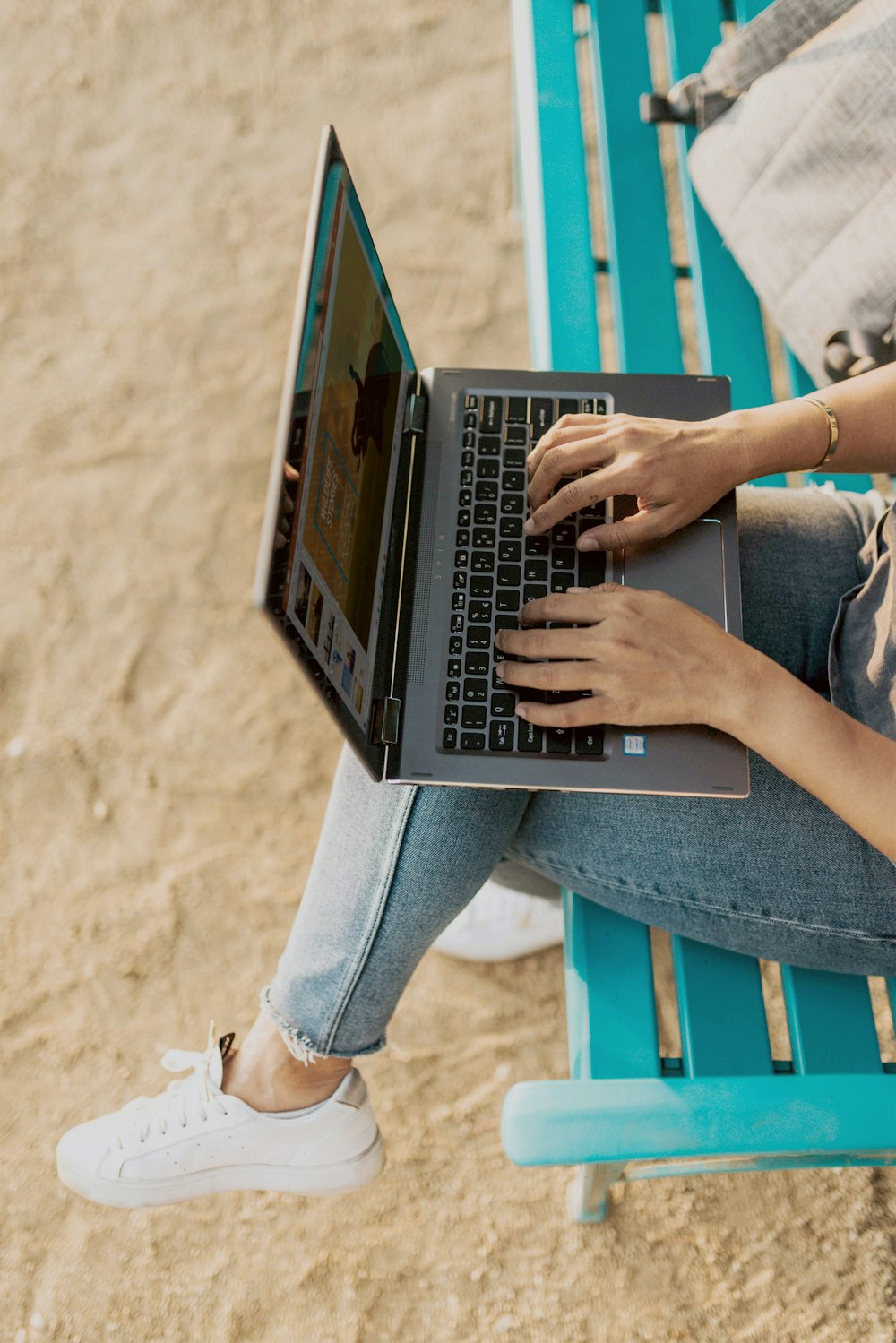 person in blue denim jeans using laptop