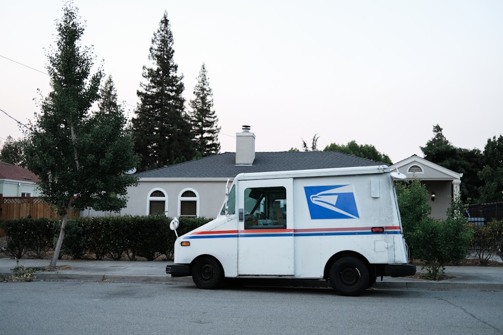 white and blue usps truck mail on road during daytime