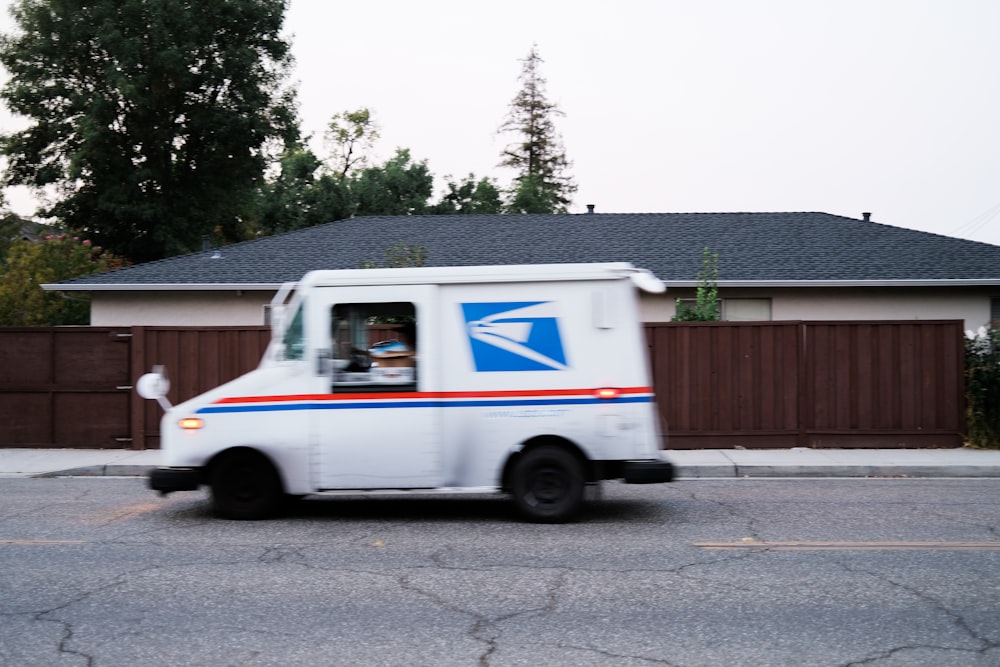 white and blue van parked on gray concrete road during daytime