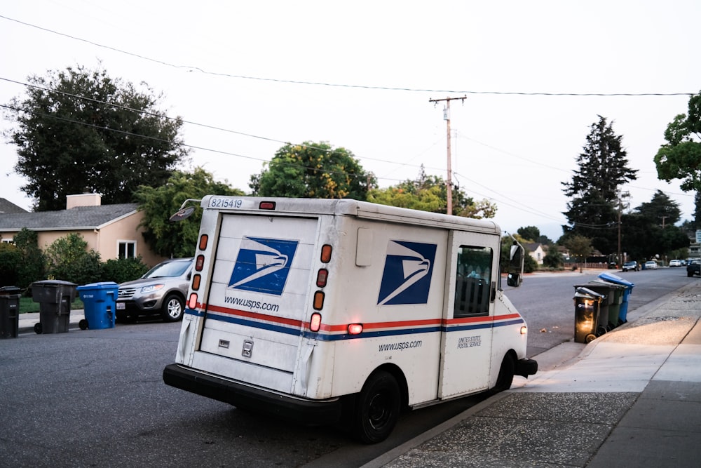 white and blue van on road during daytime mail usps arriving late