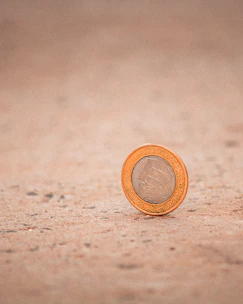 A close-up of a warm copper coin resting on a wooden surface, symbolizing value and ancient wisdom.