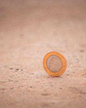 Close-up of a weathered Roman silver coin resting on a dark velvet cloth.