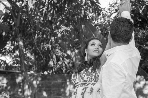 A serene black-and-white portrait of a couple embracing on a Bali beach at sunset.