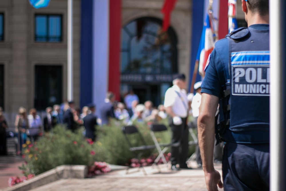 homem de camiseta azul e shorts pretos andando na rua durante o dia