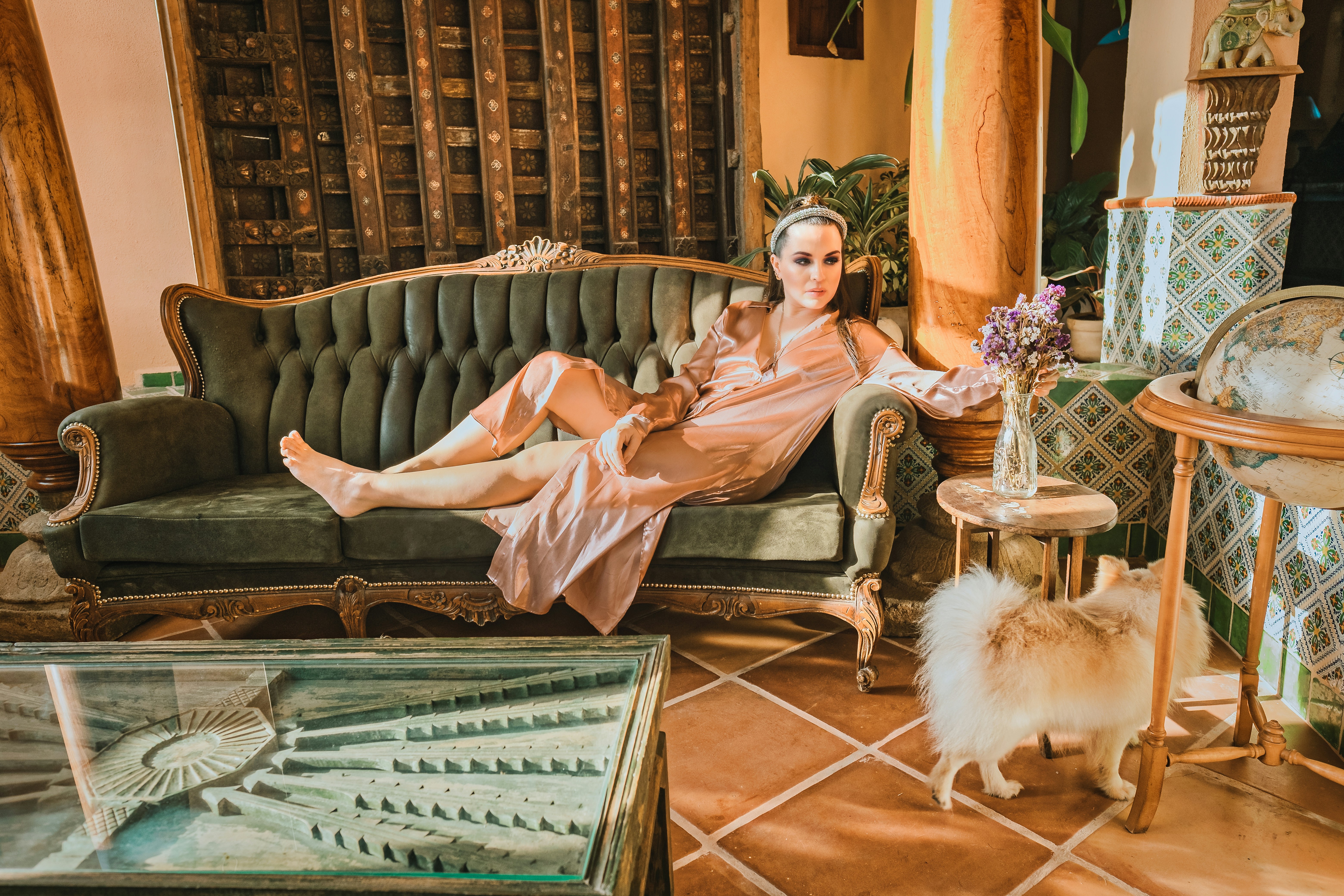 woman in pink robe sitting on green sofa