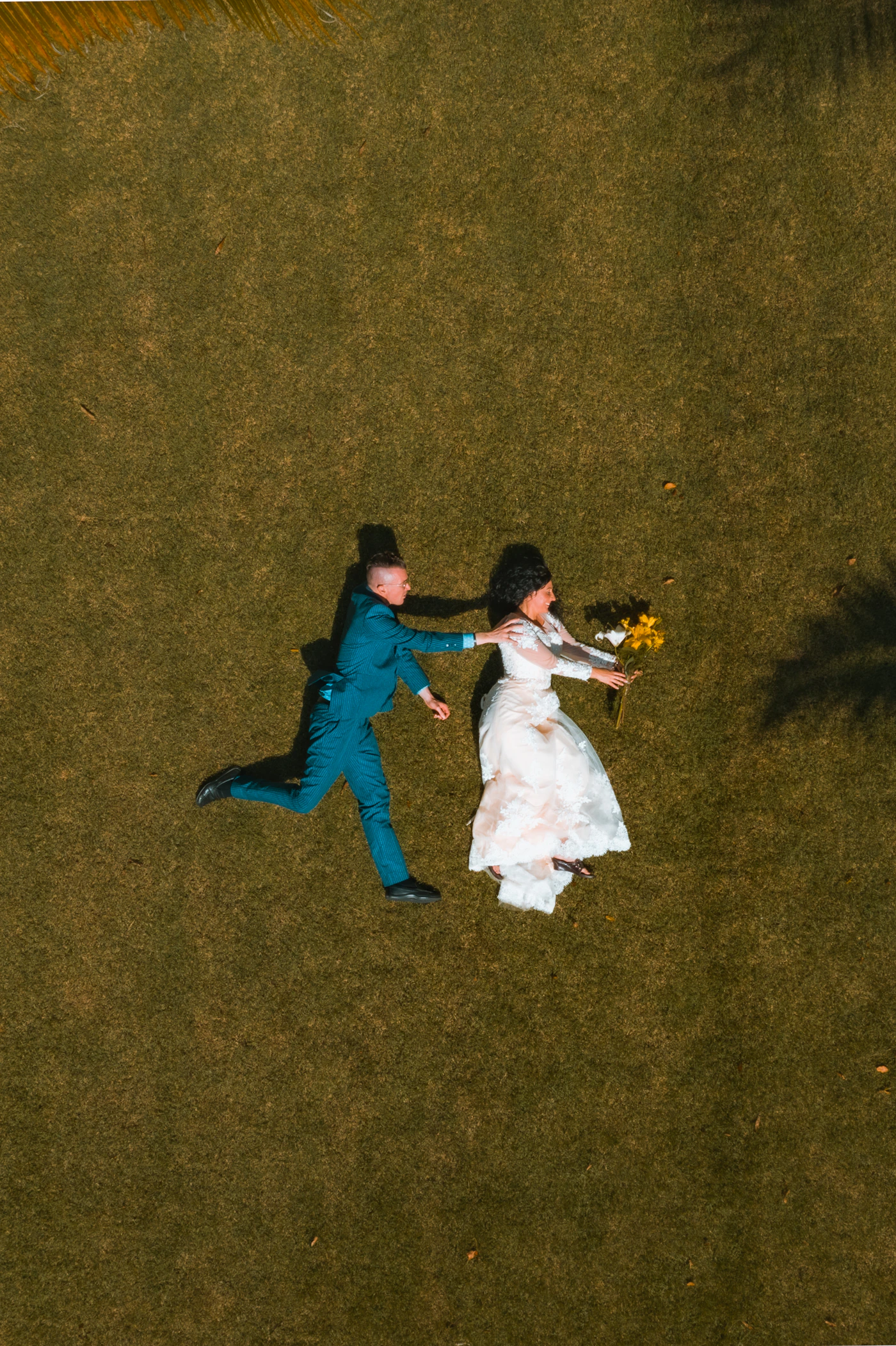Playful couple in wedding attire together outdoors