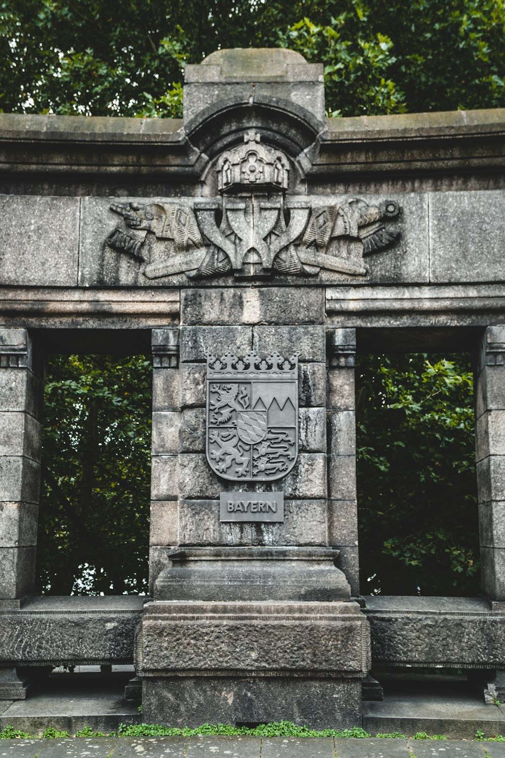 grey concrete statue near green trees during daytime