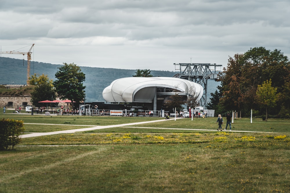 people walking on green grass field near white airplane under white clouds during daytime