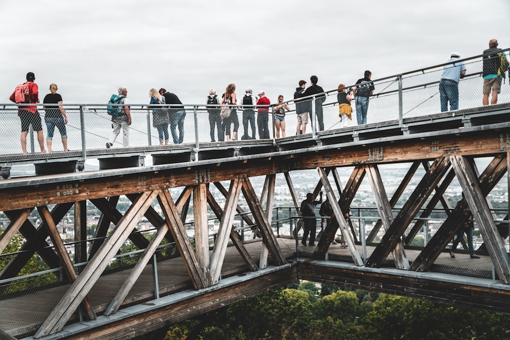 personnes marchant sur un pont en bois pendant la journée