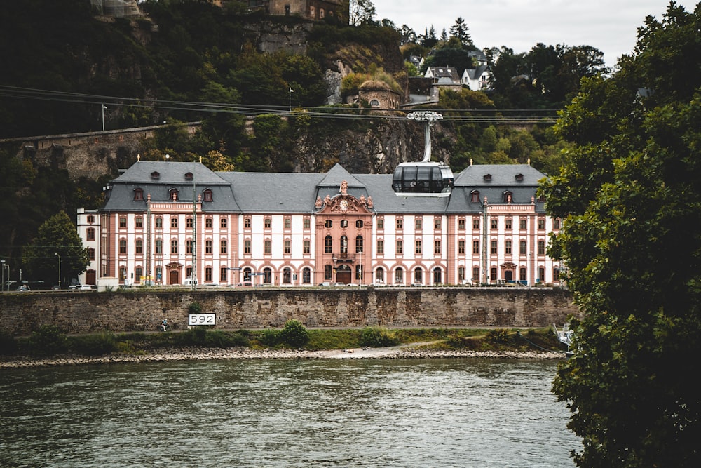 Bâtiment en béton blanc et rouge près d’un plan d’eau pendant la journée