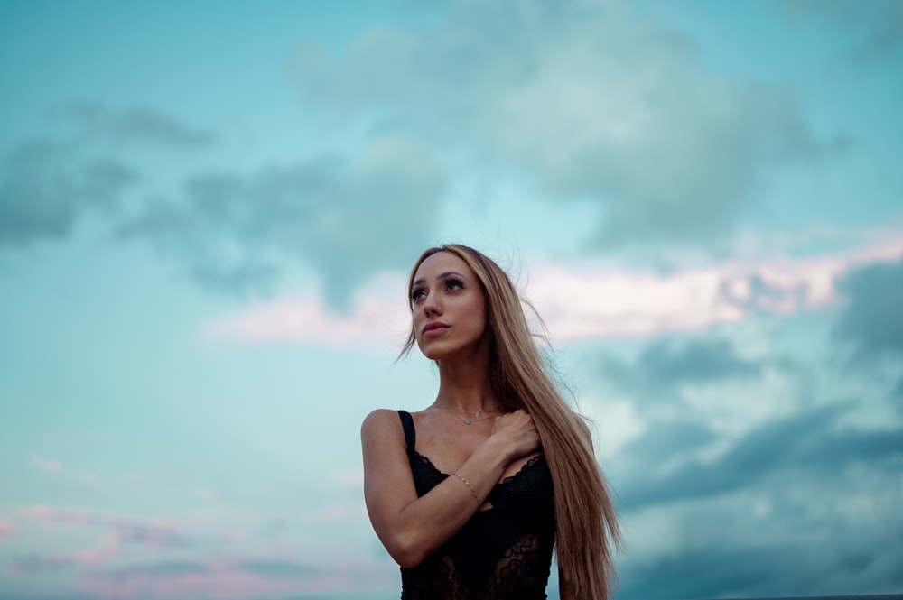 woman in black spaghetti strap top under blue sky during daytime