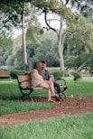woman in black dress sitting on brown wooden bench