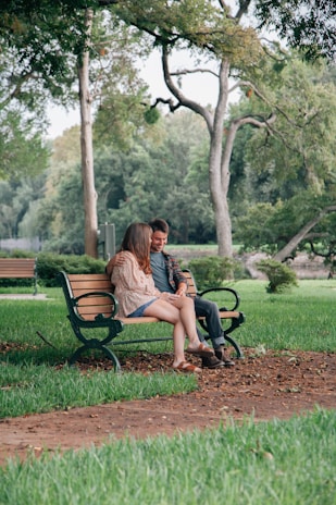 woman in black dress sitting on brown wooden bench