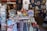A vibrant storefront displaying a variety of traditional Japanese items including Maneki-neko statues, decorative fans, t-shirts with Japanese motifs, and an assortment of small souvenirs. The arrangement of the items creates an inviting and colorful atmosphere.