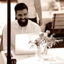 A friendly local business owner smiling while using a laptop to contact Parr Websites.