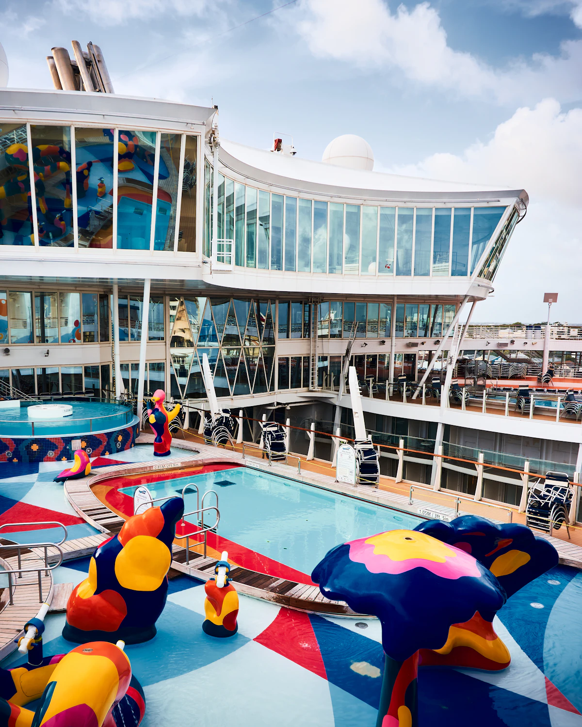 The upper pool deck of a large cruise ship on a bright day