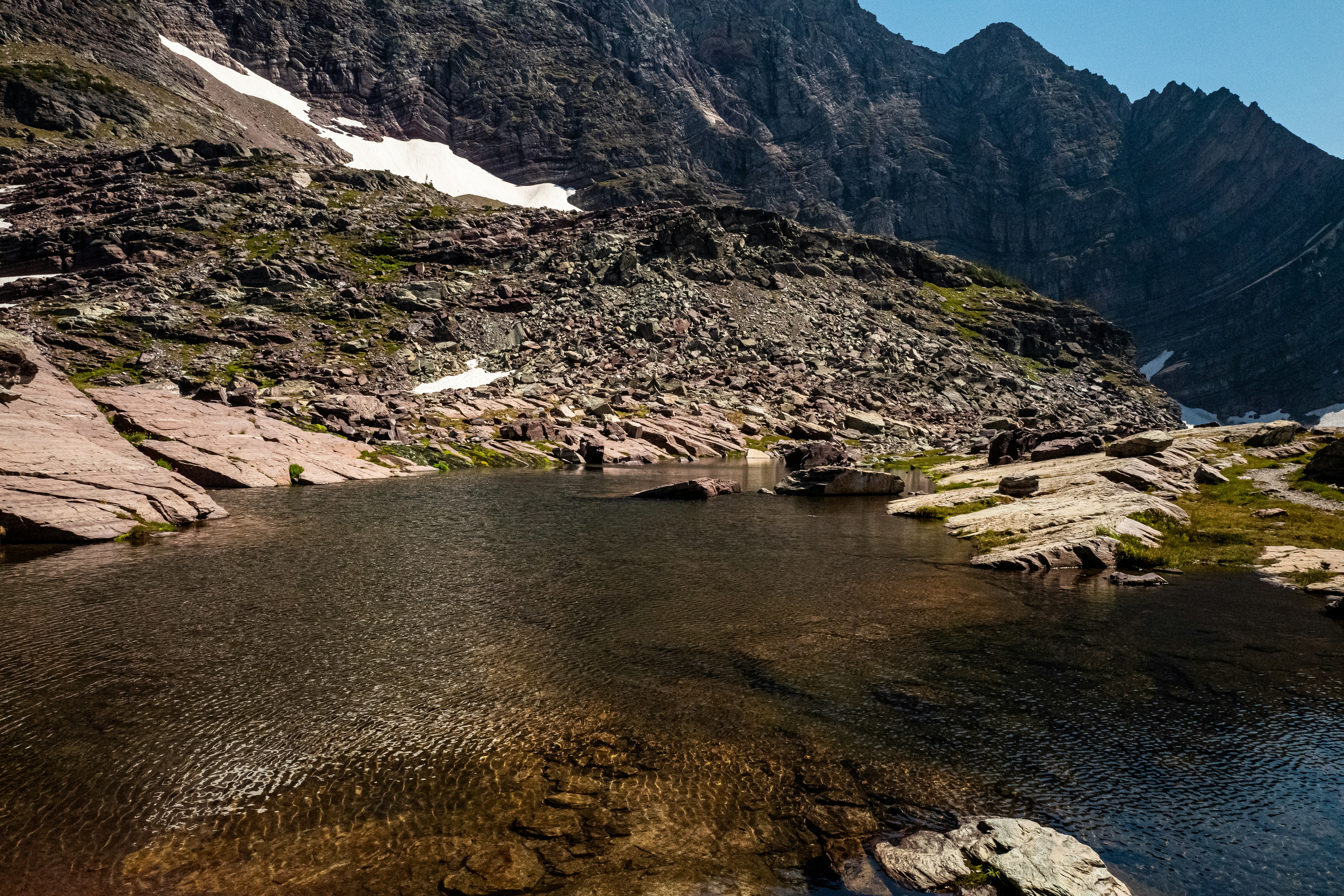 body of water near mountain during daytime
